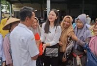 Ketua Karang Taruna Kendal Nattaya Kenenza, S.H. berbincang dengan pedagang Pasar Gladag saat menyerahkan bantuan sembako pasca banjir, Rabu (29/10/2025). | Wawasannews