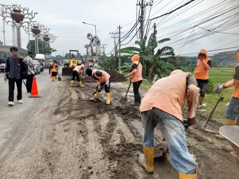 Petugas gabungan dari Dishub, Satlantas Polres Kendal, dan Damkar melakukan pembersihan tumpukan lumpur di jalur perbatasan Kota Kendal, Desa Sumberejo, Kaliwungu, Kamis (13/11/2025), untuk mencegah kecelakaan akibat jalan licin. (Istimewa/Wawasannews)