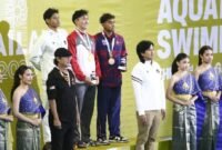 Perenang Indonesia Joe Aditya Wijaya Kurniawan (kiri) berdiri di podium peraih medali perak nomor 100 meter gaya kupu-kupu putra SEA Games Thailand 2025. (Istimewa/Wawasannews)