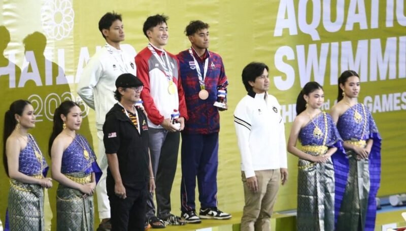 Perenang Indonesia Joe Aditya Wijaya Kurniawan (kiri) berdiri di podium peraih medali perak nomor 100 meter gaya kupu-kupu putra SEA Games Thailand 2025. (Istimewa/Wawasannews)