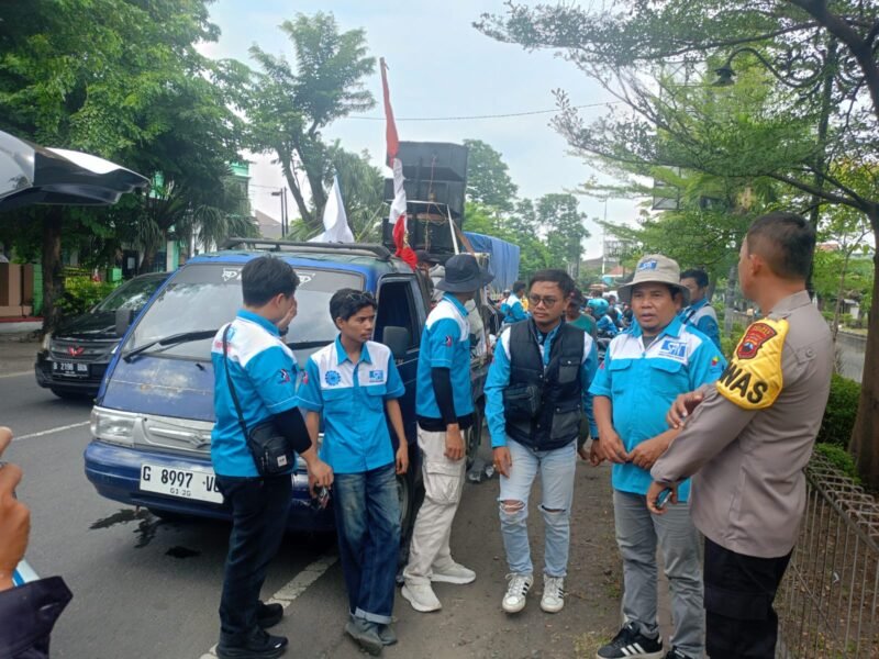 Para peserta aksi dari Serikat Pekerja melakukan long march, dengan pengawalan petugas kepolisian. (Istimewa/Wawasannews)