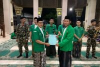 Ketua PAC GP Ansor Kecamatan Kangkung menyerahkan SK pengurus secara simbolis kepada PR GP Ansor Desa Kangkung. (Istimewa/Wawasnnews)