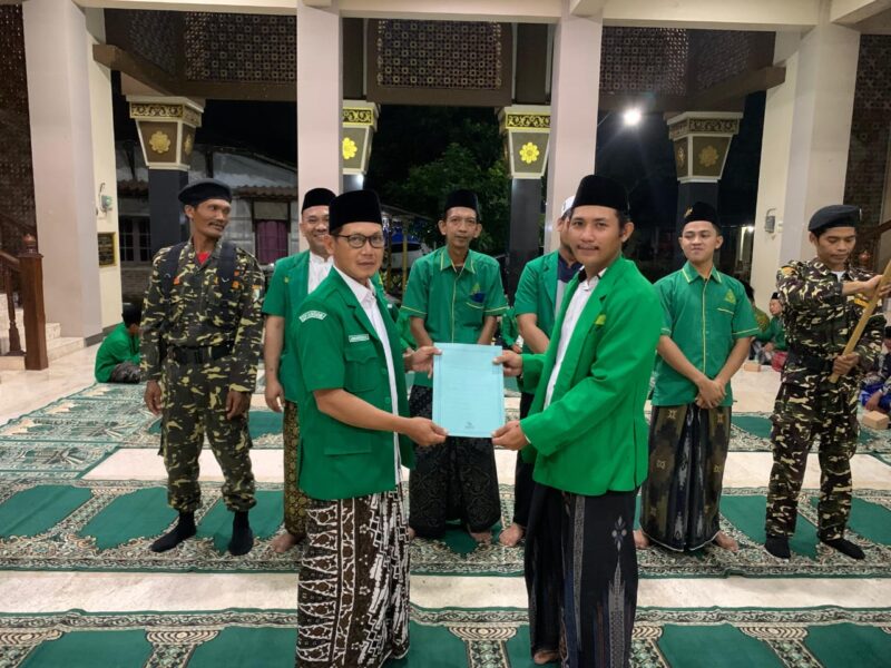 Ketua PAC GP Ansor Kecamatan Kangkung menyerahkan SK pengurus secara simbolis kepada PR GP Ansor Desa Kangkung. (Istimewa/Wawasnnews)