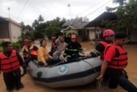 Personel BPBD tengah mengevakuasi warga dengan perahu karet saat banjir melanda. (Istimewa/Wawasannews)
