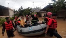 Personel BPBD tengah mengevakuasi warga dengan perahu karet saat banjir melanda. (Istimewa/Wawasannews)