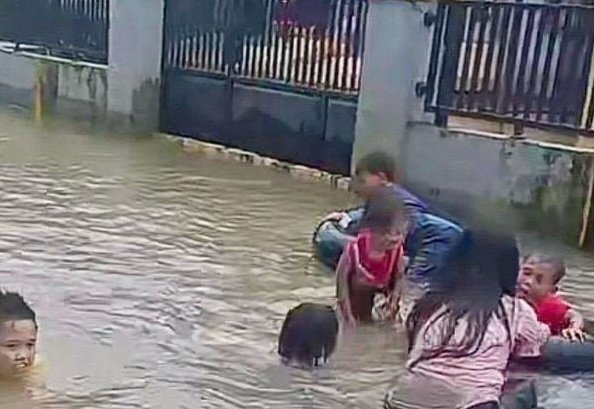 Anak-anak bermain air banjir menggunakan ban mobil di kawasan permukiman Desa Bulung Timur, Kecamatan Jekulo, Kabupaten Kudus, Jawa Tengah, Selasa (13/1/2026). (Istimewa/Wawasannews)