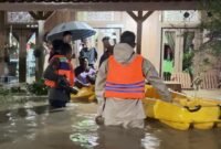 Petugas Polres Kendal mengevakuasi warga terdampak banjir menggunakan perahu karet di Desa Kebonadem, Kecamatan Brangsong, Kamis (15/1/2026). (Istimewa/Wawasannews)