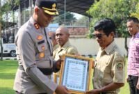 Kapolres Kendal AKBP Hendry Susanto Sianipar, S.I.K., M.H., menyerahkan piagam penghargaan kepada perwakilan masyarakat yang berjasa dalam kegiatan kemanusiaan saat Upacara Hari Kesadaran Nasional di halaman Mapolres Kendal, Senin (19/1/2026). (Istimewa/Wawasannews)
