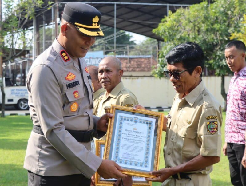 Kapolres Kendal AKBP Hendry Susanto Sianipar, S.I.K., M.H., menyerahkan piagam penghargaan kepada perwakilan masyarakat yang berjasa dalam kegiatan kemanusiaan saat Upacara Hari Kesadaran Nasional di halaman Mapolres Kendal, Senin (19/1/2026). (Istimewa/Wawasannews)