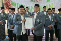 Ketua PC IPNU Kabupaten Kendal M. Samsul Muarif (kanan)  menyerahkan surat keputusan (SK) kepengurusan kepada Ketua PAC IPNU Kecamatan Kaliwungu Selatan Andika Raehan (kiri) masa khidmah 2025–2027. Dok Pribadi PAC. (Wawasannews)