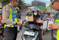 Petugas Satlantas Polres Kendal memberikan edukasi keselamatan berlalu lintas sekaligus membagikan bingkisan kepada pengendara sepeda motor saat Operasi Keselamatan Candi 2026 di Kota Kendal, Rabu (4/2/2026), sebagai upaya membangun budaya tertib berkendara. (Istimewa/Wawasannews)