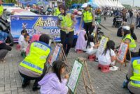 Personel Satlantas Polres Kendal mendampingi anak-anak saat mengikuti kegiatan mewarnai dalam rangka sosialisasi Operasi Keselamatan Candi 2026 melalui konsep Art Policing di Stadion Baru Kebondalem, Minggu (8/2/2026). (Istimewa/Wawasannews)