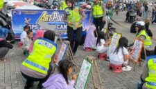 Personel Satlantas Polres Kendal mendampingi anak-anak saat mengikuti kegiatan mewarnai dalam rangka sosialisasi Operasi Keselamatan Candi 2026 melalui konsep Art Policing di Stadion Baru Kebondalem, Minggu (8/2/2026). (Istimewa/Wawasannews)