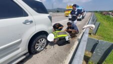 Personel Satgas Kamseltibcarlantas Polres Kendal membantu pemudik mengganti ban kendaraan yang pecah di ruas Tol Batang–Semarang KM 387A, Sabtu (14/3/2026). Foto : Wawasannews.com