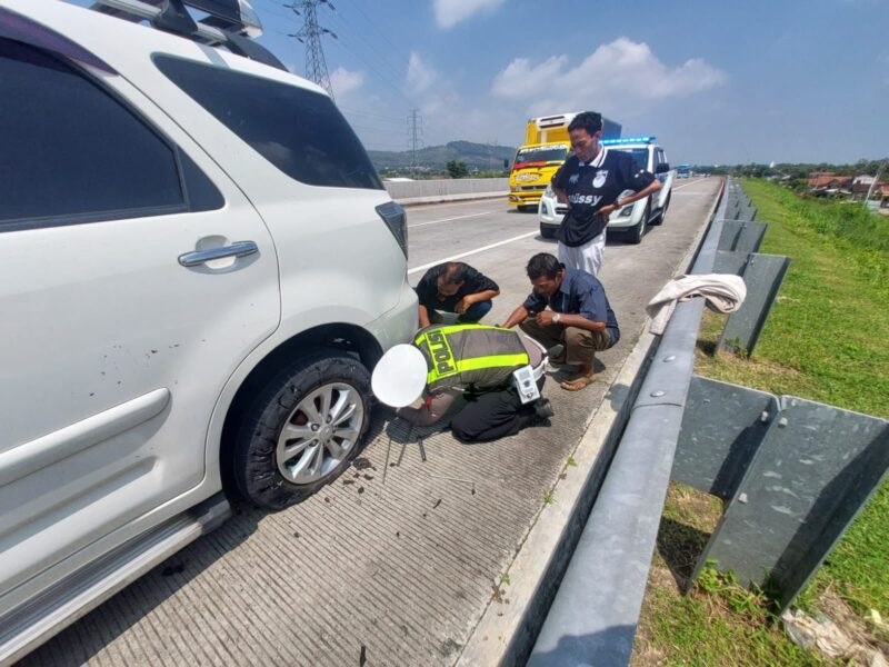 Personel Satgas Kamseltibcarlantas Polres Kendal membantu pemudik mengganti ban kendaraan yang pecah di ruas Tol Batang–Semarang KM 387A, Sabtu (14/3/2026). Foto : Wawasannews.com