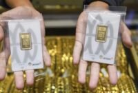 Pramuniaga menunjukkan emas batangan di sebuah gerai penjualan emas. (Istimewa/Wawasannews)