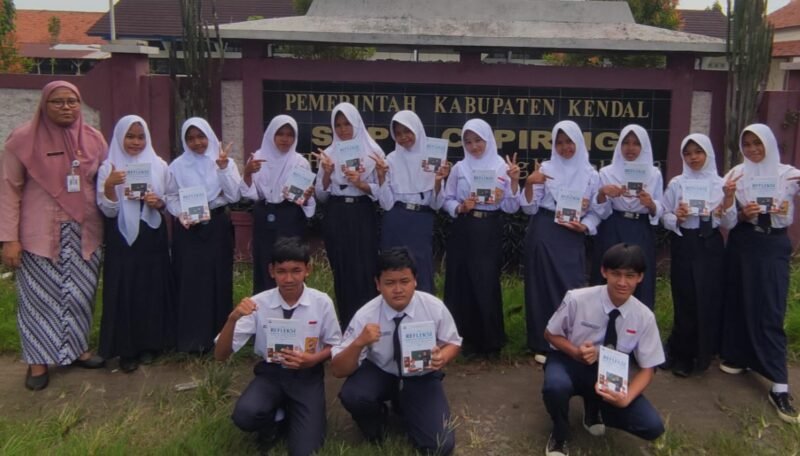 Siswa SMPN 2 Cepiring bersama guru Bahasa Inggris Ana Rahmawati Ningsih, menunjukkan buku Refleksi Pembelajaran Bahasa Inggris Guru dan Siswa Tahun Ajaran 2025-2026. (Istimewa/Wawasannews)