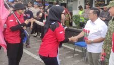 Ketua DPRD Kendal Mahfud Sodiq menyambut kedatangan buruh dengan memberikan bunga mawar di halaman Mapolres Kendal, Jumat (1/5/2026). (Istimewa/Wawasannews)