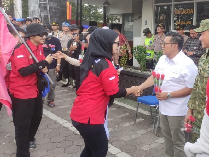 Ketua DPRD Kendal Mahfud Sodiq menyambut kedatangan buruh dengan memberikan bunga mawar di halaman Mapolres Kendal, Jumat (1/5/2026). (Istimewa/Wawasannews)