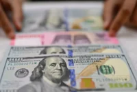 Arsip - Karyawan memperlihatkan uang pecahan rupiah dan dolar Amerika Serikat (AS) di gerai penukaran mata uang asing Ayu Masagung, Jakarta, Selasa (12/5/2026). (Istimewa/Wawasannews)