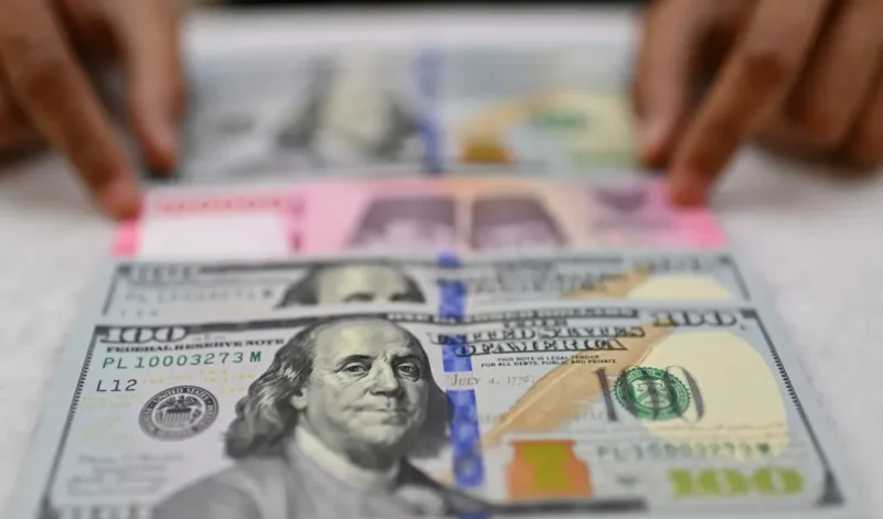 Arsip - Karyawan memperlihatkan uang pecahan rupiah dan dolar Amerika Serikat (AS) di gerai penukaran mata uang asing Ayu Masagung, Jakarta, Selasa (12/5/2026). (Istimewa/Wawasannews)