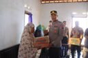 Kapolres Kendal AKBP Hendry Susanto Sianipar menyerahkan bantuan sembako kepada Siti Rokhanah, warga Kelurahan Balok yang masih bertahan tinggal di kawasan terdampak banjir rob, saat kegiatan Bakti Sosial Hari Bhayangkara ke-80, Senin (15/6/2026). (Istimewa/Wawasannes)
